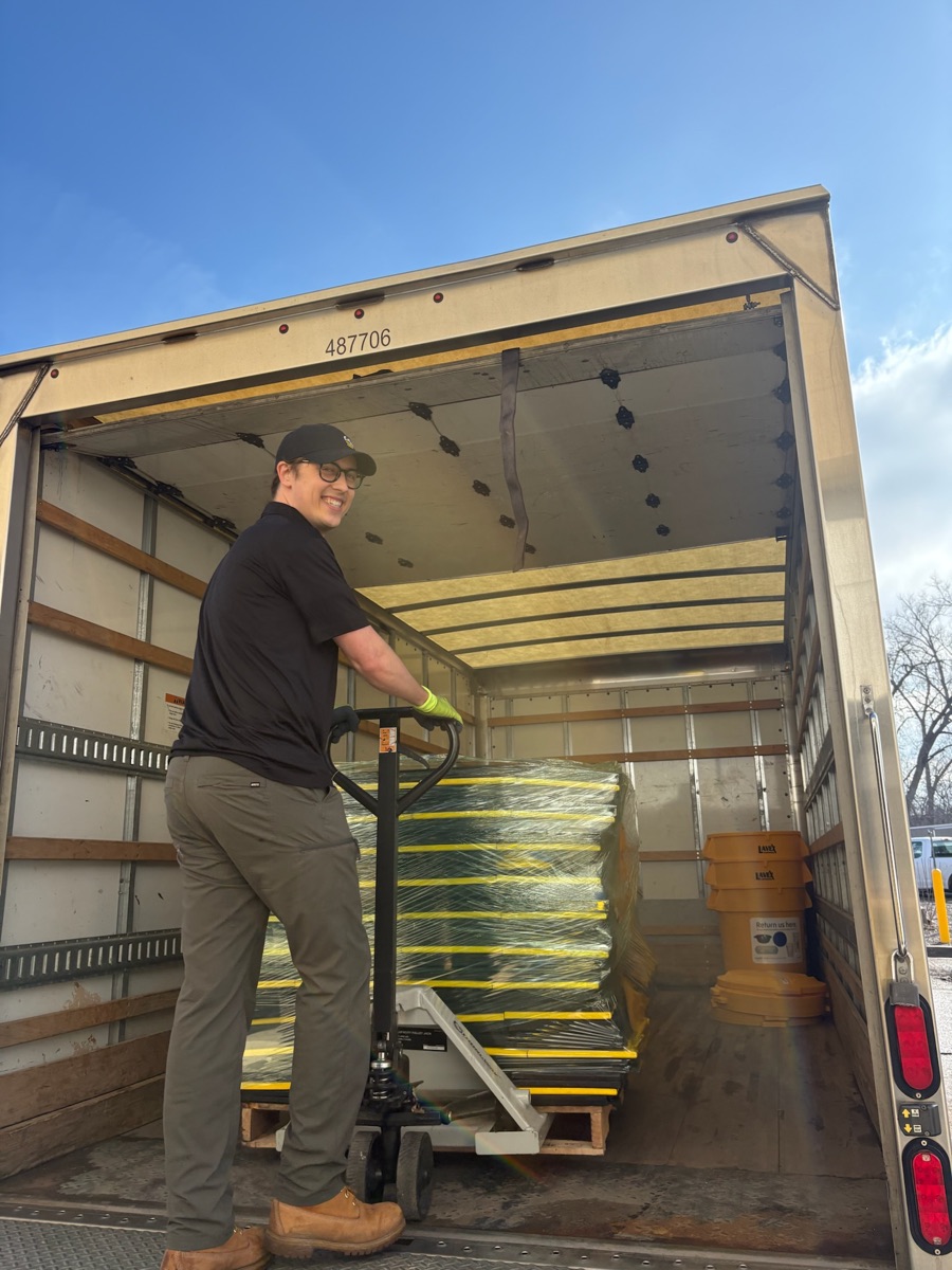 r.World driver loading reusable cups onto a delivery truck