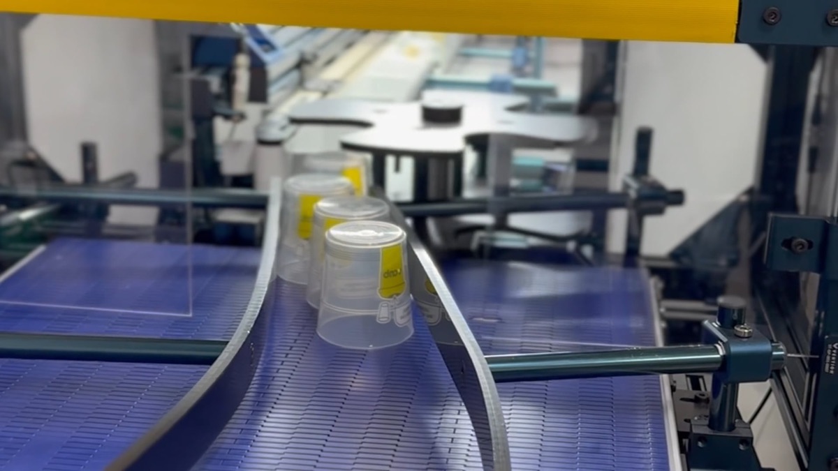Racks of washed reusable cups ready for automated quality inspection